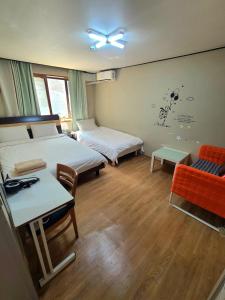 Habitación con 2 camas, mesa y sofá en Appletree Guesthouse, en Seúl