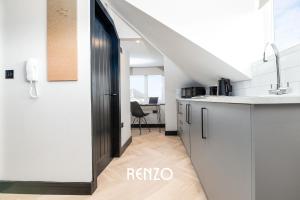 a kitchen with white cabinets and a black door at Bright and Warm Studio Apartment in Derby by Renzo, Brilliant Location, Free Parking! in Derby