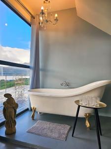 a bath tub in a bathroom with a large window at Best Place Ever in Hout Bay