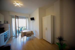 a room with a kitchen with a table and a refrigerator at Casa Primavera in Ventimiglia