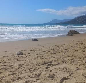 two large rocks in the sand on a beach at Casa Primavera in Ventimiglia