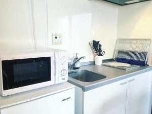 uma cozinha com um micro-ondas e um lavatório em Roppongi Place em Tóquio