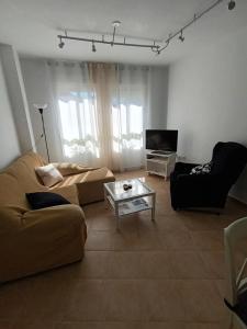 a living room with a couch and a coffee table at Alojamiento El Pilar in Güéjar-Sierra
