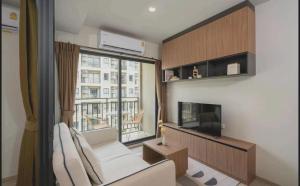 a living room with a large window and a tv at LAHABANA Resort in Hua Hin