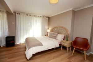 a bedroom with a large bed and a chair at Sunset Balcony Bass Coast Beach House in Grantville