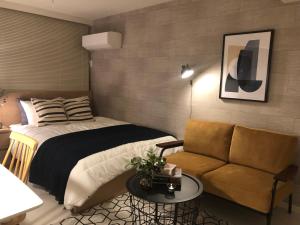 a bedroom with a bed and a couch at Roppongi Place in Tokyo