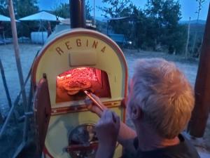 a man is eating food in a toy oven at Moto Pareto B&B in Pareto