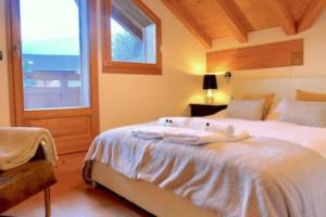 Schlafzimmer mit einem großen weißen Bett und einem Fenster in der Unterkunft Classy Alpine Hideaway in the Portes du Soleil in Montriond