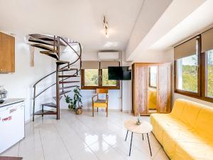 a living room with a yellow couch and a spiral staircase at Studio Acropolis Serres Next to Center in Serres