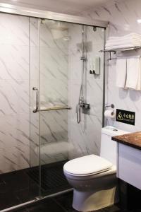 銅仁的住宿－铜仁世纪大酒店，一间带卫生间和玻璃淋浴间的浴室