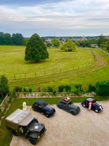 un grupo de tres coches estacionados en un campo en Château de Montaupin, en Oizé