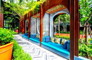 a garden with an arbor and blue benches at LAHABANA Resort in Hua Hin