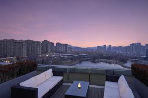 a rooftop patio with a view of a city at Sheraton Qingdao Licang Hotel in Qingdao