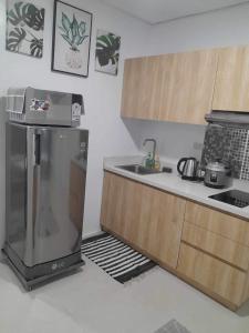 a kitchen with a refrigerator and a sink at The Hideaway at Citta Verde Primavera City in Cagayan de Oro