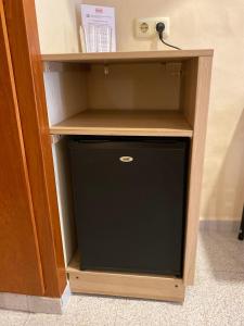 a small wooden shelf with a small black cabinet at Pensión Coral in Barcelona