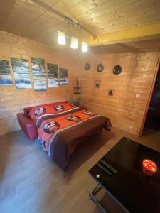 ein Schlafzimmer mit einem Bett in einem Holzzimmer in der Unterkunft HOUDARLING Chalet avec Hammam Sauna Jacuzzi Privatif in Nîmes