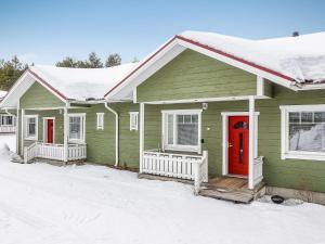 SaarenkyläにあるHoliday Home Huoneisto b2 by Interhomeの雪中赤い扉のある緑の家