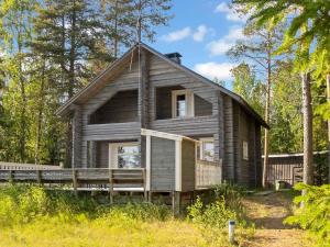 a log cabin in the woods with a porch at Holiday Home Joulupukin mökki by Interhome in Sonka