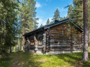 eine Blockhütte im Wald mit Bäumen in der Unterkunft Holiday Home Ukkohermanni by Interhome in Luosto