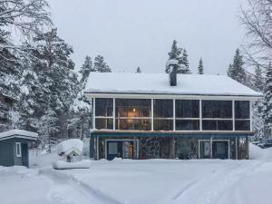 una casa cubierta de nieve en el patio en Holiday Home Äkäsjärven lomamökit 3 by Interhome, en Rauhala