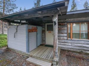 uma cabana de madeira com um alpendre com uma placa em Holiday Home Ylläsrivit c 8 - villa änkyrä by Interhome em Ylläsjärvi