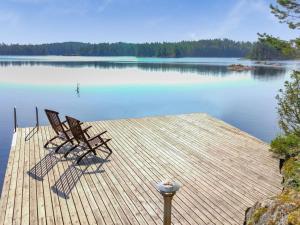 dos sillas sentadas en un muelle en un lago en Holiday Home Sointukallio by Interhome, en Savonlinna