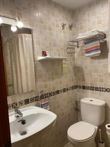 Łazienka z białą toaletą i umywalką w obiekcie Pensión Coral w Barcelonie