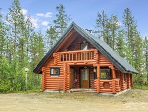 uma cabana na floresta com um telhado preto em Holiday Home Fassen maja by Interhome em Ylläsjärvi