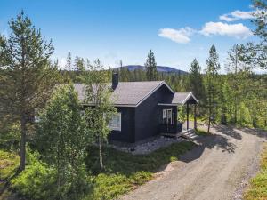 a home in the woods with a dirt road at Holiday Home Tuulenpuuska by Interhome in Äkäslompolo