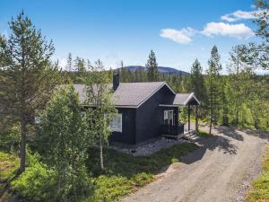 a home in the woods with a dirt road at Holiday Home Tuulenpuuska by Interhome in Äkäslompolo