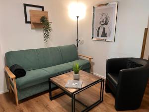 ein Wohnzimmer mit einer grünen Couch und einem Tisch in der Unterkunft Apartment Top 49A by Interhome in Heiligenblut