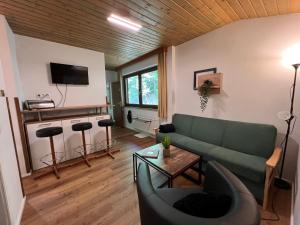 ein Wohnzimmer mit einer grünen Couch und einem Tisch in der Unterkunft Apartment Top 49A by Interhome in Heiligenblut + 25 Fotos
