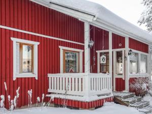 a red house with snow on the side of it at Holiday Home Villa unari by Interhome in Unari