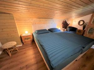 a bedroom with a large bed in a wooden room at Apartment Glockner-2 by Interhome in Heiligenblut