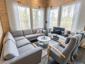 uma sala de estar com um sofá e uma televisão em Holiday Home Päivänsäde 8 lapinkulta by Interhome em Äkäslompolo