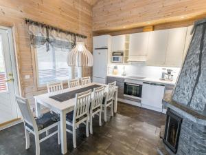 uma cozinha e sala de jantar com mesa e cadeiras em Holiday Home Päivänsäde 8 lapinkulta by Interhome em Äkäslompolo