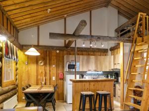 LahdenperäにあるHoliday Home Vuokatinportti a 9 by Interhomeの木製の壁のキッチン(テーブル、椅子付)