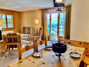 una sala de estar con una mesa con copas de vino. en Apartment Colline 3 by Interhome, en Champex