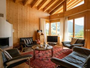 a living room with couches and a table and a tv at Holiday Home Midat Soleil by Interhome in Verbier