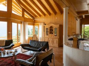 una sala de estar con muebles de cuero y techo de madera. en Holiday Home Midat Soleil by Interhome, en Verbier