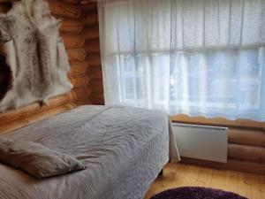 um quarto com uma cama em frente a uma janela em Holiday Home Lintukoto by Interhome em Äkäslompolo