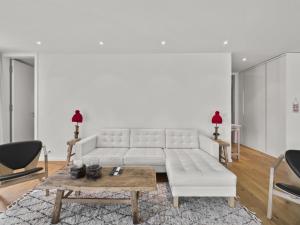 a living room with a white couch and a table at Apartment Triangel Raber by Interhome in Parpan