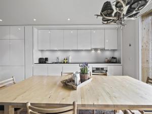 a kitchen with a wooden table and white cabinets at Apartment Triangel Raber by Interhome in Parpan