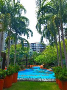 uma grande piscina com palmeiras num parque em LAHABANA Resort em Hua Hin