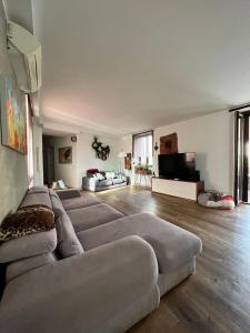 een grote woonkamer met een bank en een flatscreen-tv bij Regis 2 Appartamenti Resort centro storico in Chivasso