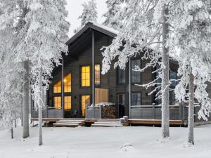 a log cabin in the woods in the snow at Holiday Home Westlevi b by Interhome in Sirkka