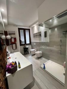 La salle de bains est pourvue d'une baignoire, de toilettes et d'une douche. dans l'établissement Regis 2 Appartamenti Resort centro storico, à Chivasso