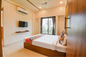 a bedroom with a bed and a window at FabHotel Royal Hospitality in Pune