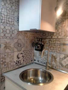 a stainless steel sink in a kitchen with tiles at Setta Apartment in Lido di Ostia