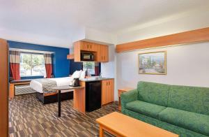 a hotel room with a couch and a bed at Microtel Inn and Suites by Wyndham - Cordova in Memphis
